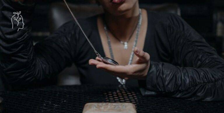 Femme tenant un pendule dans ses mains