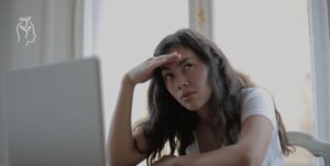 Jeune femme qui en a marre de travailler sur son ordinateur